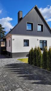 a white house with a black roof and a driveway at Ferienwohnung 2 - "Ferienhaus Seibert" in Ellerdorf