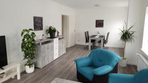 a living room with a blue chair and a table at Ferienwohnung 2 - "Ferienhaus Seibert" in Ellerdorf
