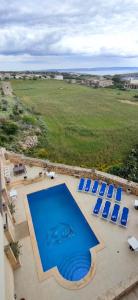una vista aérea de una piscina con sillas azules en Warda Accommodation, en Xewkija