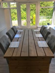 a large wooden table with chairs around it at Perfect 4 Cpls & Families . Close to Everything in Pentraeth