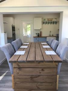 a wooden table with chairs around it in a kitchen at Perfect 4 Cpls & Families . Close to Everything in Pentraeth