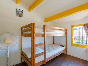 two bunk beds in a room with a fan at Villa Gruissan, 3 pièces, 6 personnes - FR-1-409A-20 in Gruissan