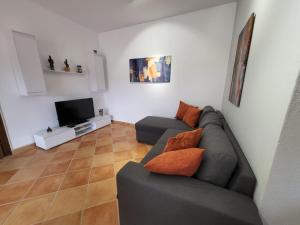 een woonkamer met een bank en een televisie bij Julia's Apartment in Golem Beach in Golem