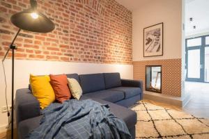 a living room with a couch and a brick wall at Villa Bellevue App 05 in Heringsdorf