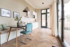 a kitchen with a table and a blue chair at Villa Bellevue App 05 in Heringsdorf