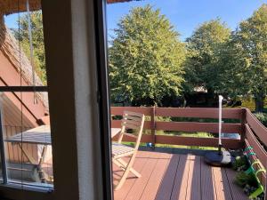 a wooden deck with a chair on a balcony at Haus 1795 Specht in Wustrow