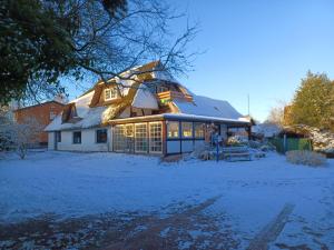 a house covered in snow with lights on it at Haus 1795 Specht in Wustrow