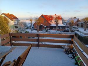 a balcony covered in snow with a house at Haus 1795 Specht in Wustrow +29 photos