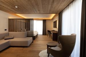um quarto de hotel com uma cama e uma secretária em Camino Rustic Chic Hotel em Livigno