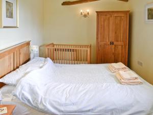 a large white bed in a bedroom with a wooden door at The Old Stables in Chetnole
