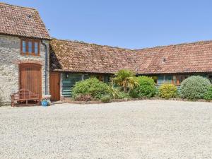 an old house with a large driveway in front of it at The Old Stables in Chetnole