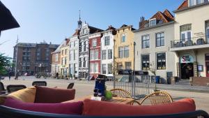 un tavolo e sedie su una strada cittadina con edifici di Rijksmonument Havenzicht, met zeezicht, ligging direct aan zee en centrum a Vlissingen