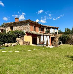 uma casa de pedra com um quintal em frente em Villa Zippiri Is Molas Pula em Pula