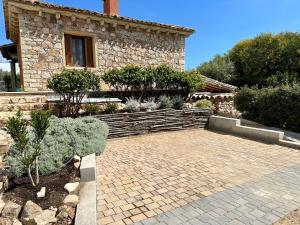 a house with a brick patio in front of it at Villa Zippiri Is Molas Pula in Pula