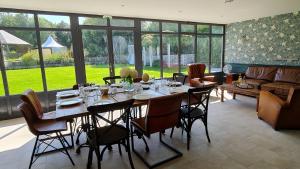 a large dining room with a table and chairs at Le Manoir des Marronniers in Sully