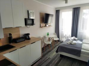 una camera con letto e una cucina con tavolo di Apartament_kubamielno a Mielno