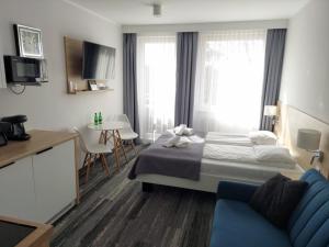 una camera d'albergo con un letto e un divano blu di Apartament_kubamielno a Mielno