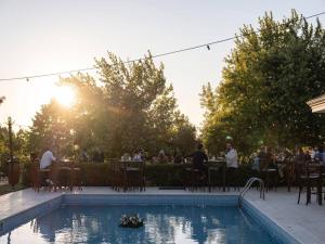 una piscina con un gruppo di persone seduti ai tavoli di Happy Farm Silivri a Silivri