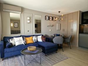 uma sala de estar com um sofá azul e uma mesa em Unique Apartment - Costa Plana em Cap d'Ail