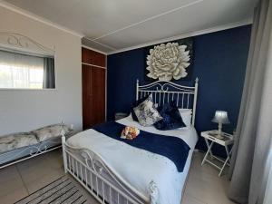 a bedroom with a white bed with blue walls at @ Home Bed & Breakfast in Brakpan