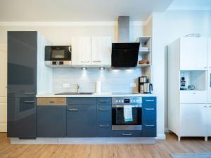 uma cozinha azul com um lavatório e um fogão em Villa Erika - App 5 em Ahlbeck