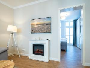 uma sala de estar com lareira e uma imagem na parede em Villa Erika - App 5 em Ahlbeck
