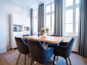 uma sala de jantar com uma mesa de madeira e cadeiras em Villa Erika - App 5 em Ahlbeck