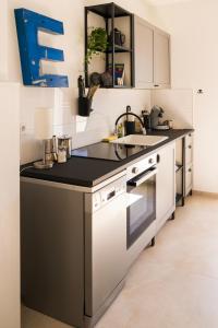 une cuisine avec des armoires blanches et un comptoir noir dans l'établissement FeelsLikeHome - Traumhafte zentrumsnahe Wohnung mit Balkon&Parkplatz, à Bochum 20 autres photos