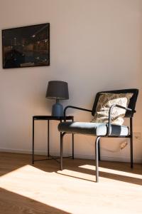 a chair in a room with a lamp and a table at FeelsLikeHome - Traumhafte zentrumsnahe Wohnung mit Balkon&Parkplatz in Bochum