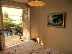 a bedroom with a bed and a view of a balcony at VillaV, seafront 2-story 4* apartment with great outdoors in Prizba