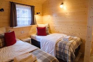 um quarto com 2 camas individuais num chalé de madeira em Domki Szarlota - atrakcje dla rodzin na Kaszubach em Kościerzyna