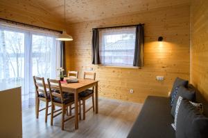 コシチェジナにあるDomki Szarlota - atrakcje dla rodzin na Kaszubachの木製のテーブルと椅子が備わる木造の客室です。