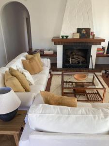a living room with two white couches and a fireplace at Villa Eugenia in La Herradura