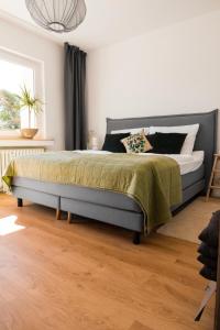 a bedroom with a large bed with a green blanket at FeelsLikeHome - Traumhafte zentrumsnahe Wohnung mit Balkon&Parkplatz in Bochum