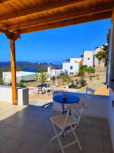 a patio with a table and chairs and a view of the ocean at Georgia Rooms Milos in Plaka Milou +60 photos