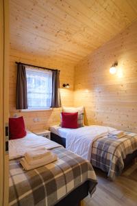 Habitación con 2 camas en una cabaña de madera en Domki Szarlota - atrakcje dla rodzin na Kaszubach, en Kościerzyna