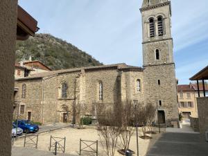 an old stone church with a tall tower at Appartement neuf avec garage in Andance