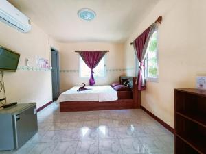 Schlafzimmer mit einem Bett, einem TV und Fenstern in der Unterkunft Win Gray Homestay Resort in Patiyu