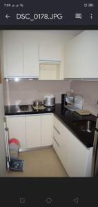 eine Küche mit weißen Schränken und einer schwarzen Arbeitsplatte in der Unterkunft Consuelo Condominium Unit Rentals in Boracay