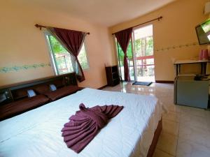 ein Schlafzimmer mit einem weißen Bett und einem Bademantel. in der Unterkunft Win Gray Homestay Resort in Patiyu