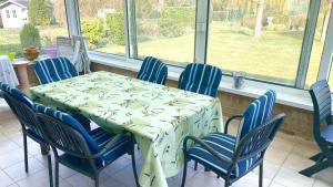 uma mesa e cadeiras num quarto com uma mesa e janelas em Villa Lucienne em Comines