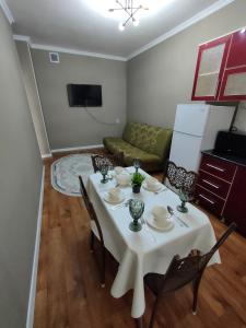 sala de estar con mesa blanca y sillas en 2 комнатная Нурсат вдоль Аллеи, en Shymkent