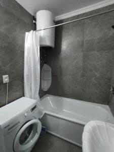 uma casa de banho com uma banheira, um WC e um lavatório. em 2 комнатная Нурсат вдоль Аллеи em Shymkent