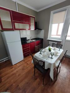 a kitchen with a white table and a white refrigerator at 2 комнатная Нурсат вдоль Аллеи in Shymkent