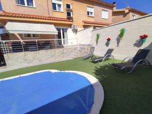 a patio with a blue table and chairs and a building at "La Villa de Iker" con Piscina, Barbacoa y a 10 mint de Puy du Fou in Argés