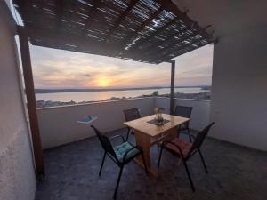 a table and chairs on a balcony with a view of the ocean at Apartmani Orešković in Kustići