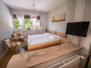 sypialnia z łóżkiem i telewizorem z płaskim ekranem w obiekcie GRANDIAL we Władysławowie