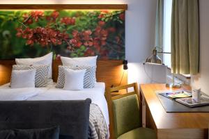 a bedroom with two beds and a desk and a painting at Hotel Szarlota - Kompleksowo na Kaszubach in Kościerzyna