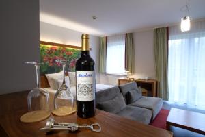 a bottle of wine and two glasses on a table at Hotel Szarlota - Kompleksowo na Kaszubach in Kościerzyna