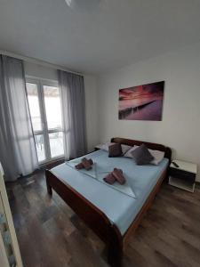 a bedroom with a large bed with two towels on it at Apartmani Orešković in Kustići